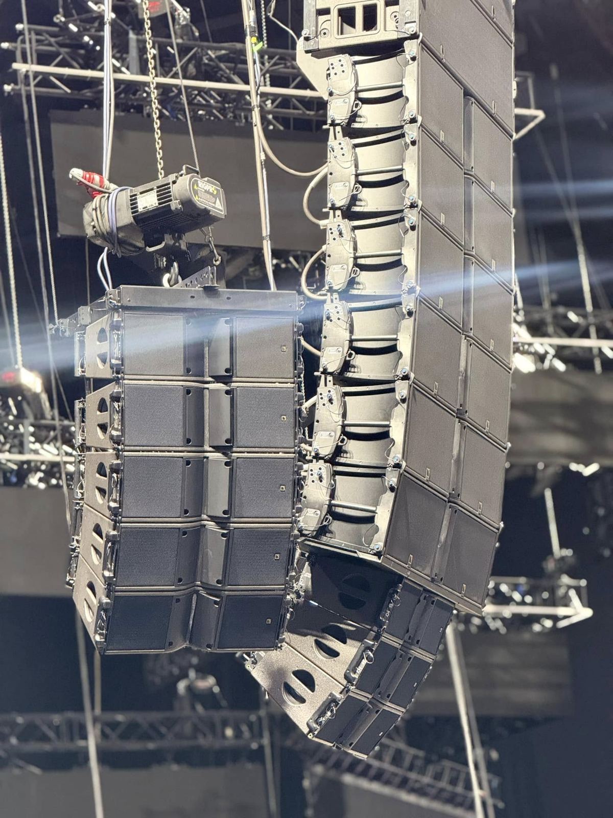 Main line array and side array being rigged in an arena