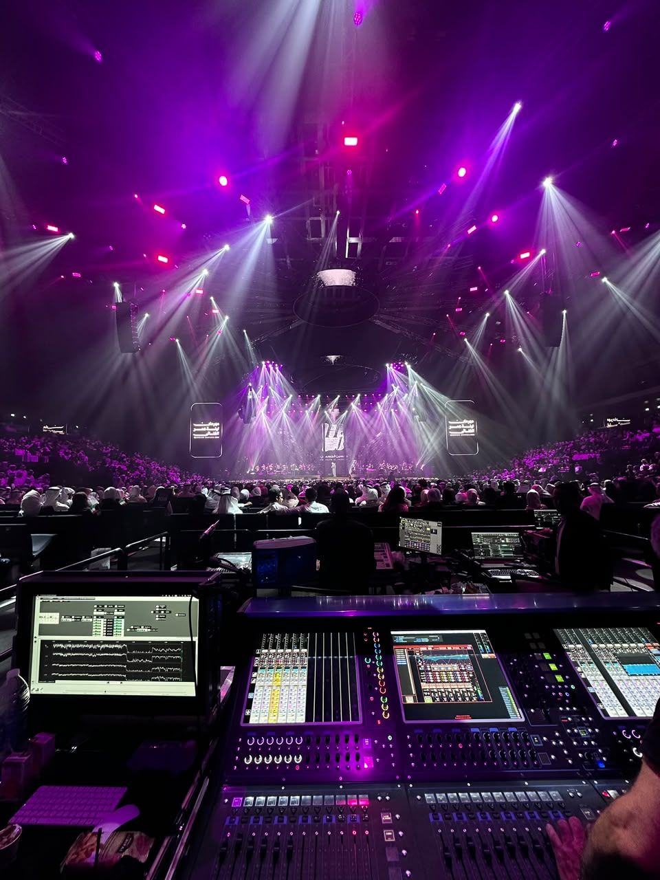 Front-of-house console during an arena show in purple light
