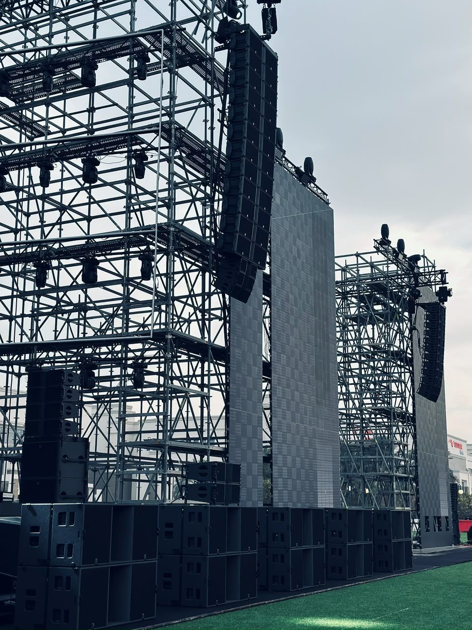 Outdoor stage scaffolding with flown line arrays and ground-stacked subwoofers