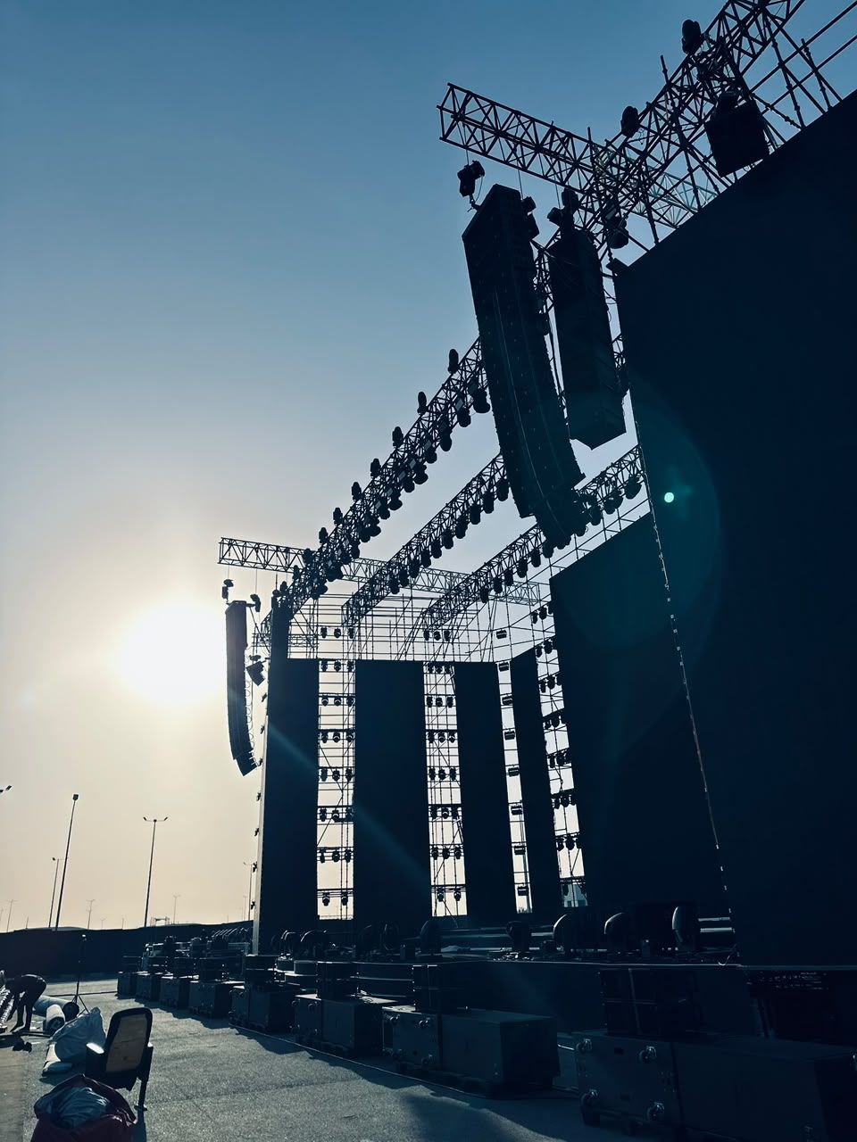 Outdoor stage structure with line arrays at sunset