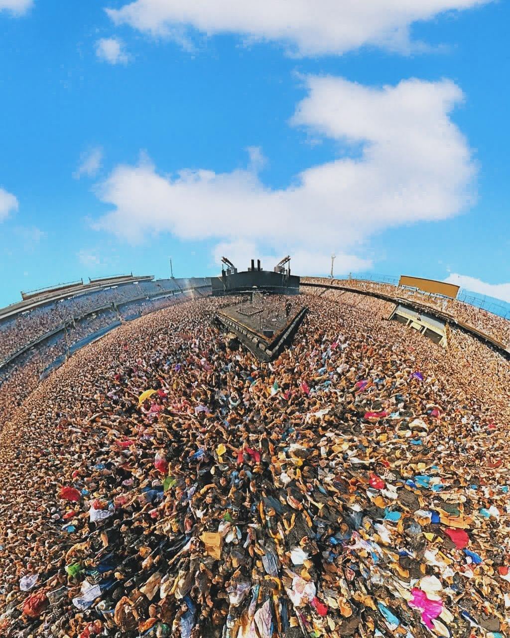 Wide fisheye view of a full stadium crowd facing the stage