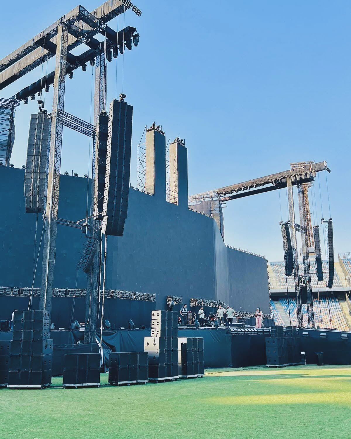 Stadium stage with tall flown line arrays and ground-stacked subwoofers