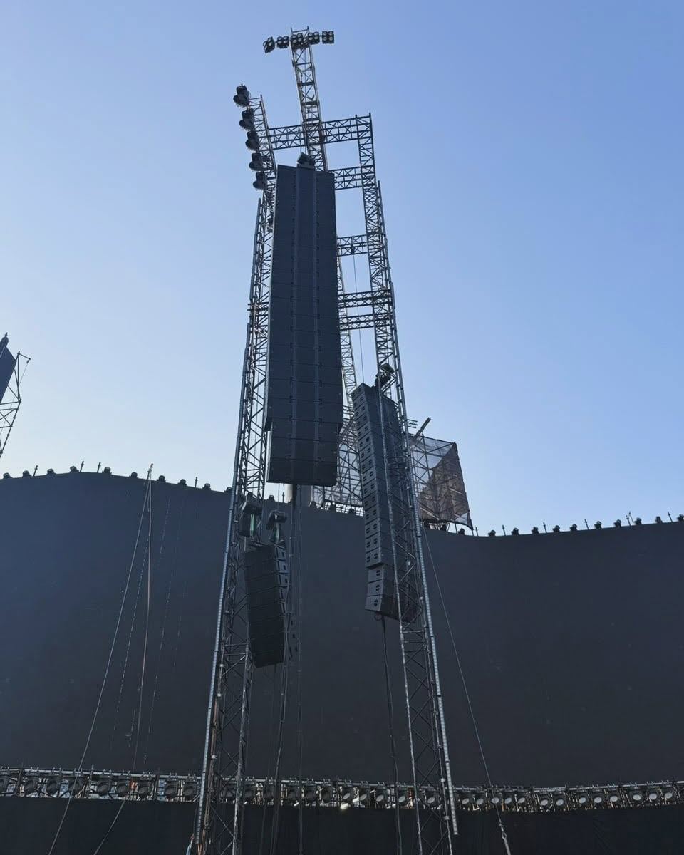 Tall line array hang on a truss tower against a blue sky