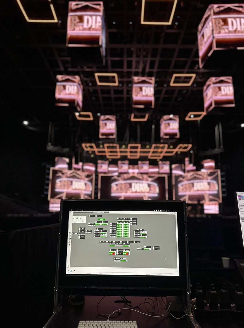 Laptop running amplifier network software beneath a ceiling of LED cubes